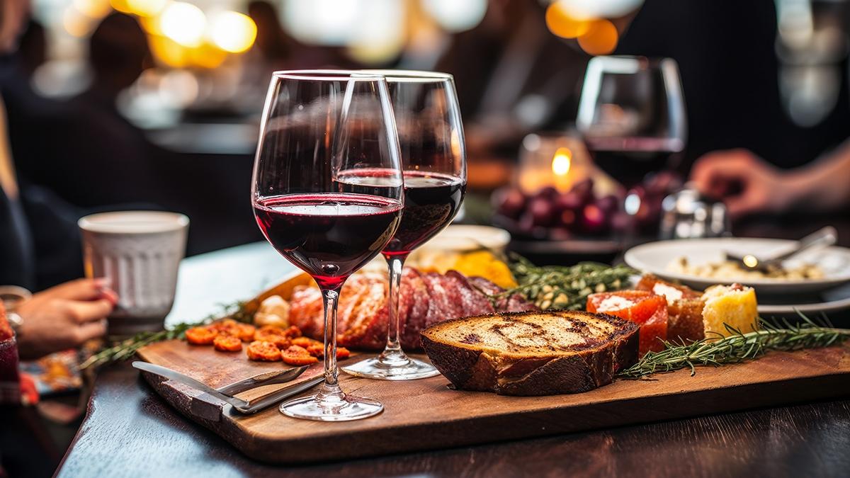 Close up of a glass of red wine on a bar table with blurred peop