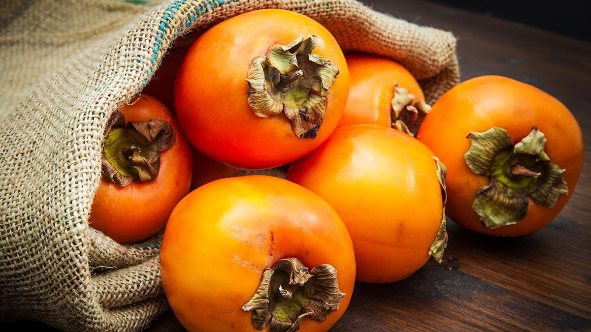 Article Cards Featured Image Delicious fresh persimmon fruit on wooden table