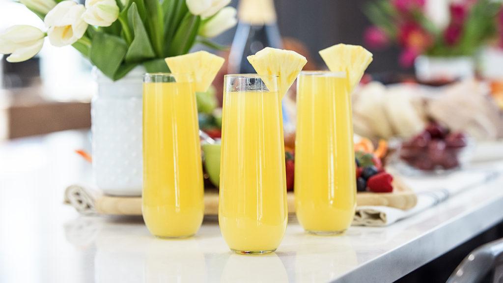 Pineapple mimosas on a kitchen counter.