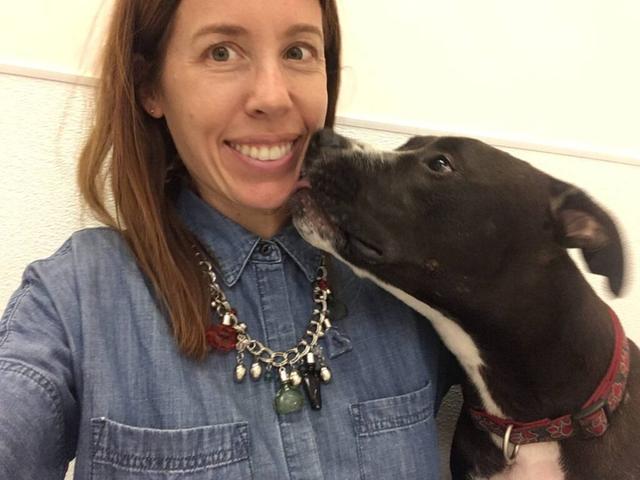 shelter animals image   woman taking a selfie of her and a dog who's licking her face.