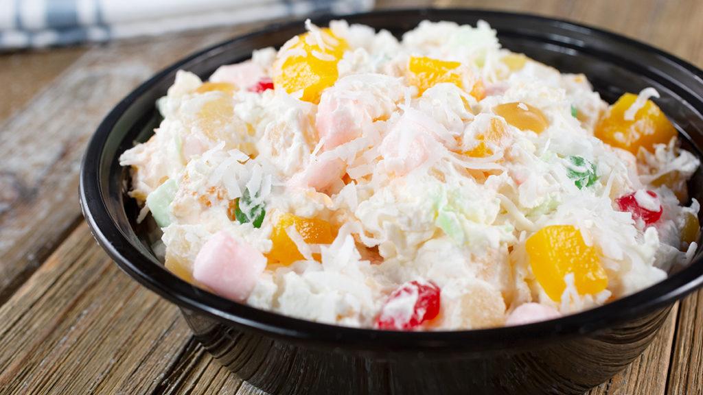 Photo of salads with an ambrosia salad in a black bowl