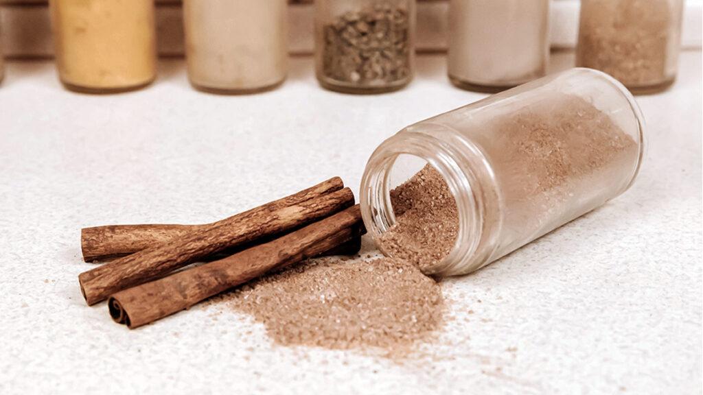 A jar of cinnamon and cinnamon sticks.