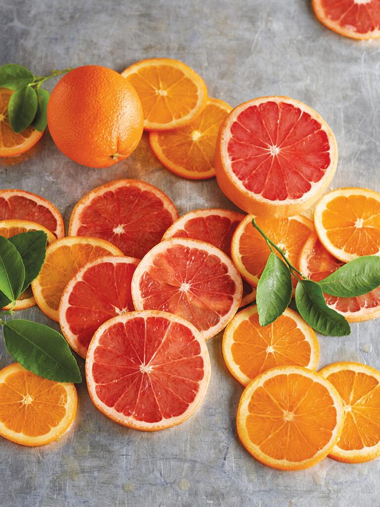 Grapefruits sliced on a grey counter top.